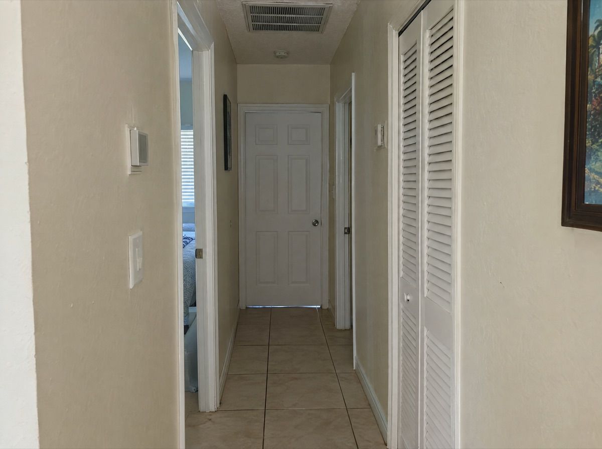 Hallway with a closed bedroom door and a ceiling air vent.