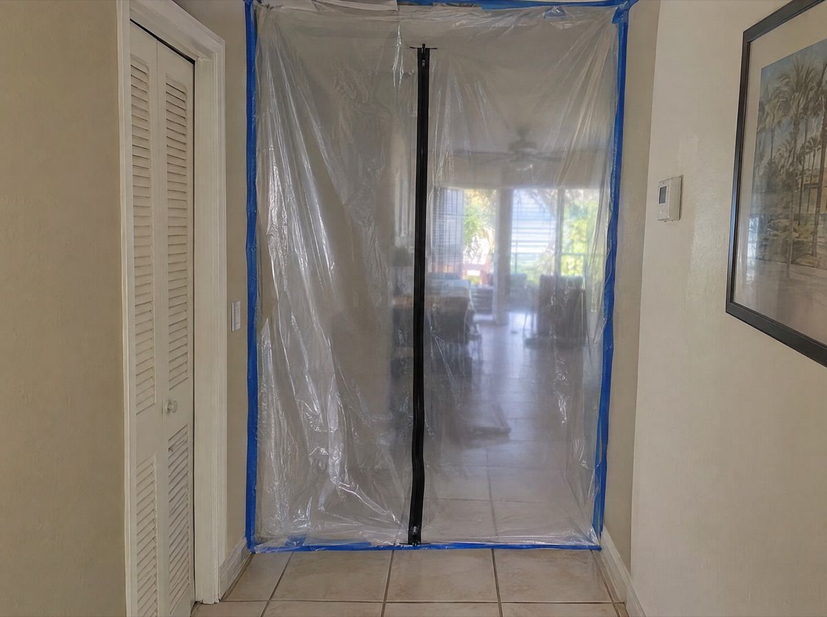 Hallway sealed off with clear plastic sheeting and a zipper door.