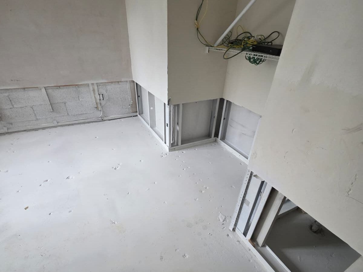 Empty room with the lower drywall removed and the concrete floor cleaned.