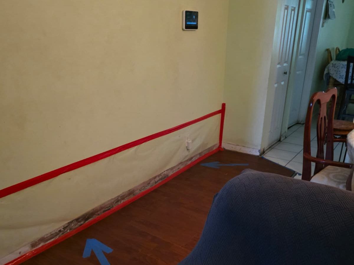Red tape marking the lower part of a wall with a dark line along the baseboard.